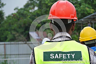 Construction workers wear safety vest has safety sign on it. Editorial Stock Photo